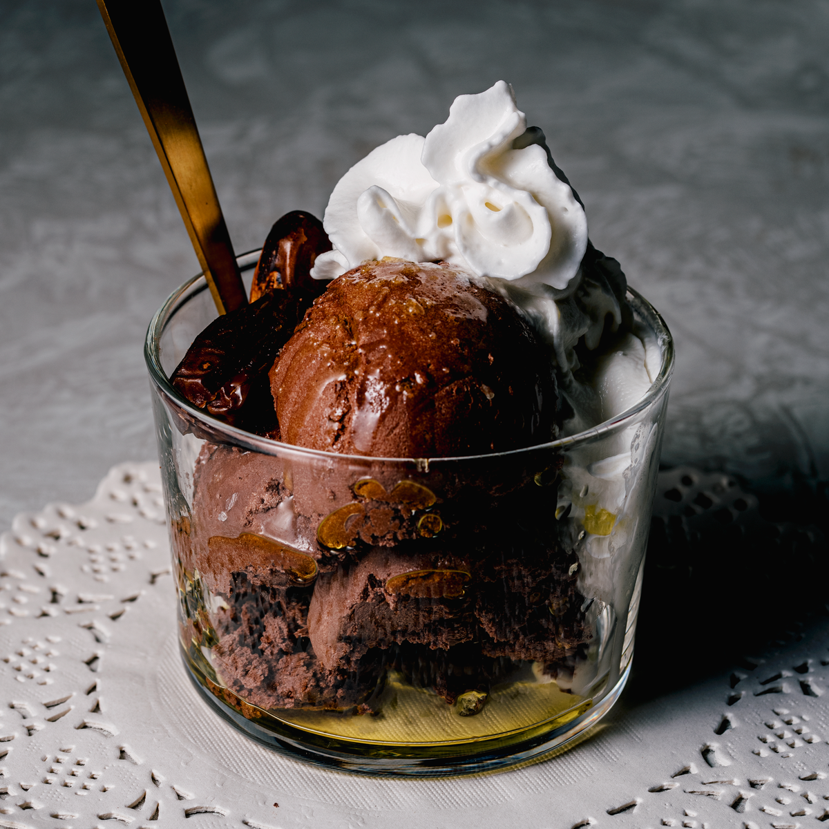 Pure Cacao & Dates & Vanilla Mousse in a clear dish with a dollop of whipped cream. 