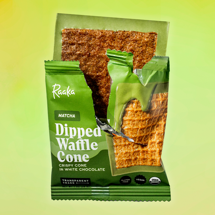 Dipped Matcha Waffle Cone bar coming out of wrapper on a green background.