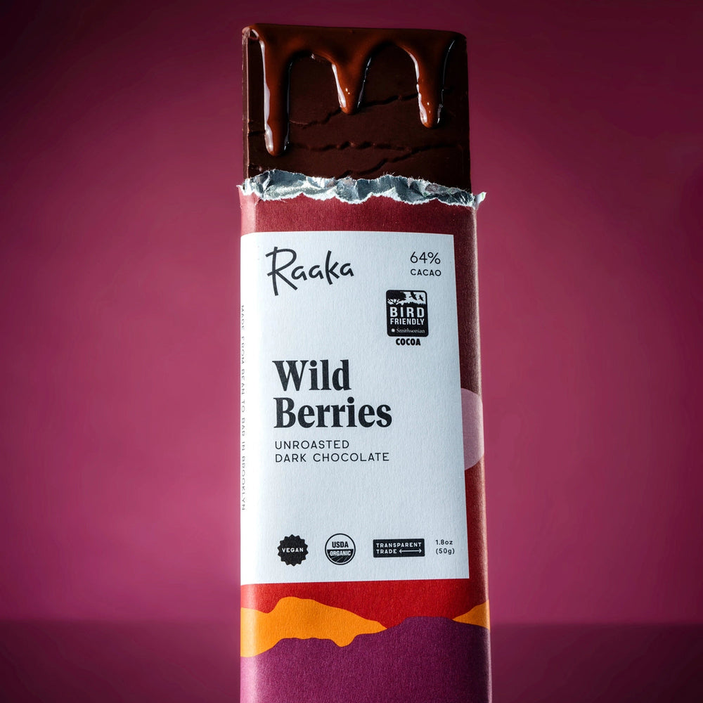 Raaka Wild Berries unroasted dark chocolate bar on a purple background