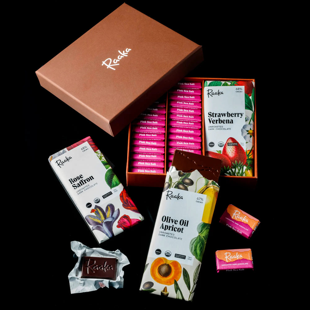 Assorted Raaka chocolate bars in open packaging on a black backgrounda