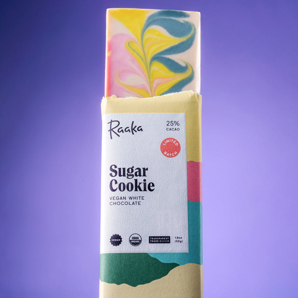 Vegan white chocolate bar with 'Sugar Cookie' flavor packaging on a purple background